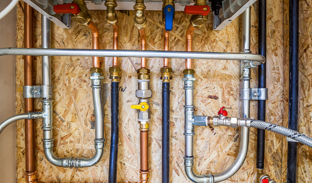 Newly installed copper and PEX plumbing pipes during a home repiping service