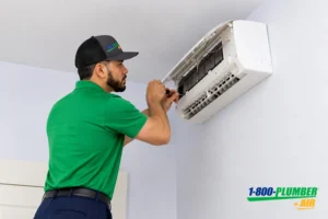 HVAC technician repairing a wall-mounted air conditioning unit
